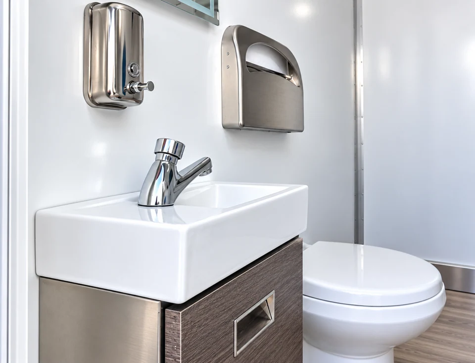 Toilet and wall-mounted sink inside a restroom-only trailer